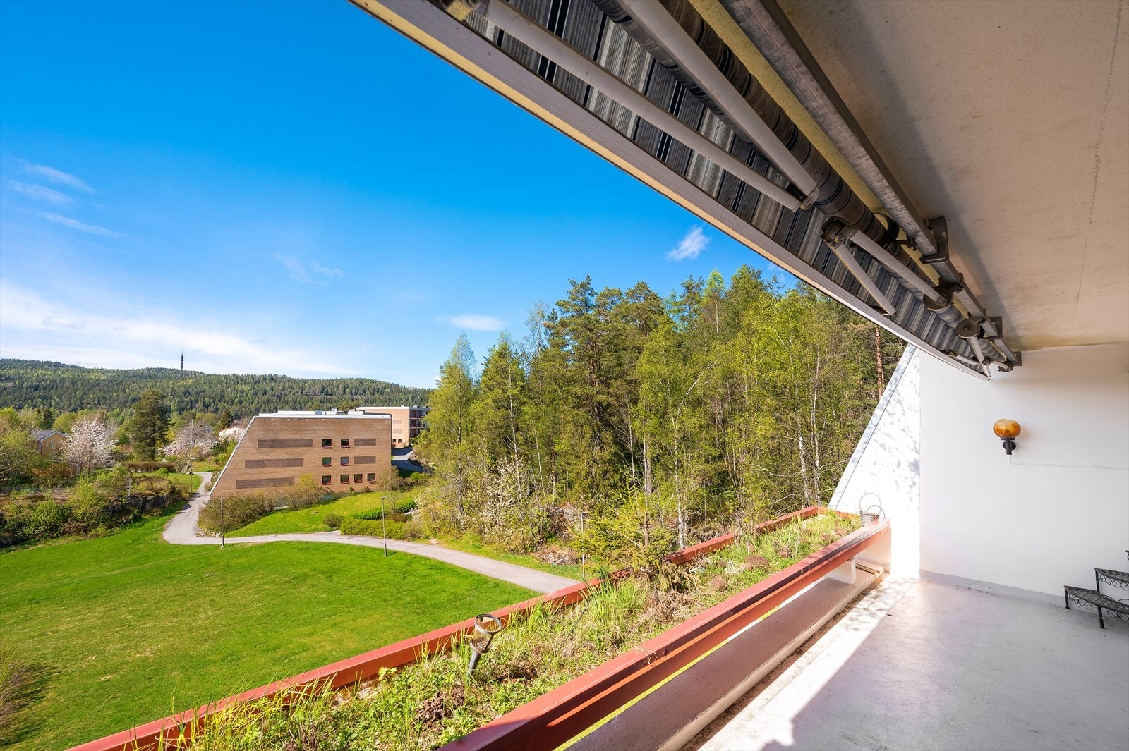 Utsikt fra balkongen mot grønne, rolige fellesarealer. Galleribilde
