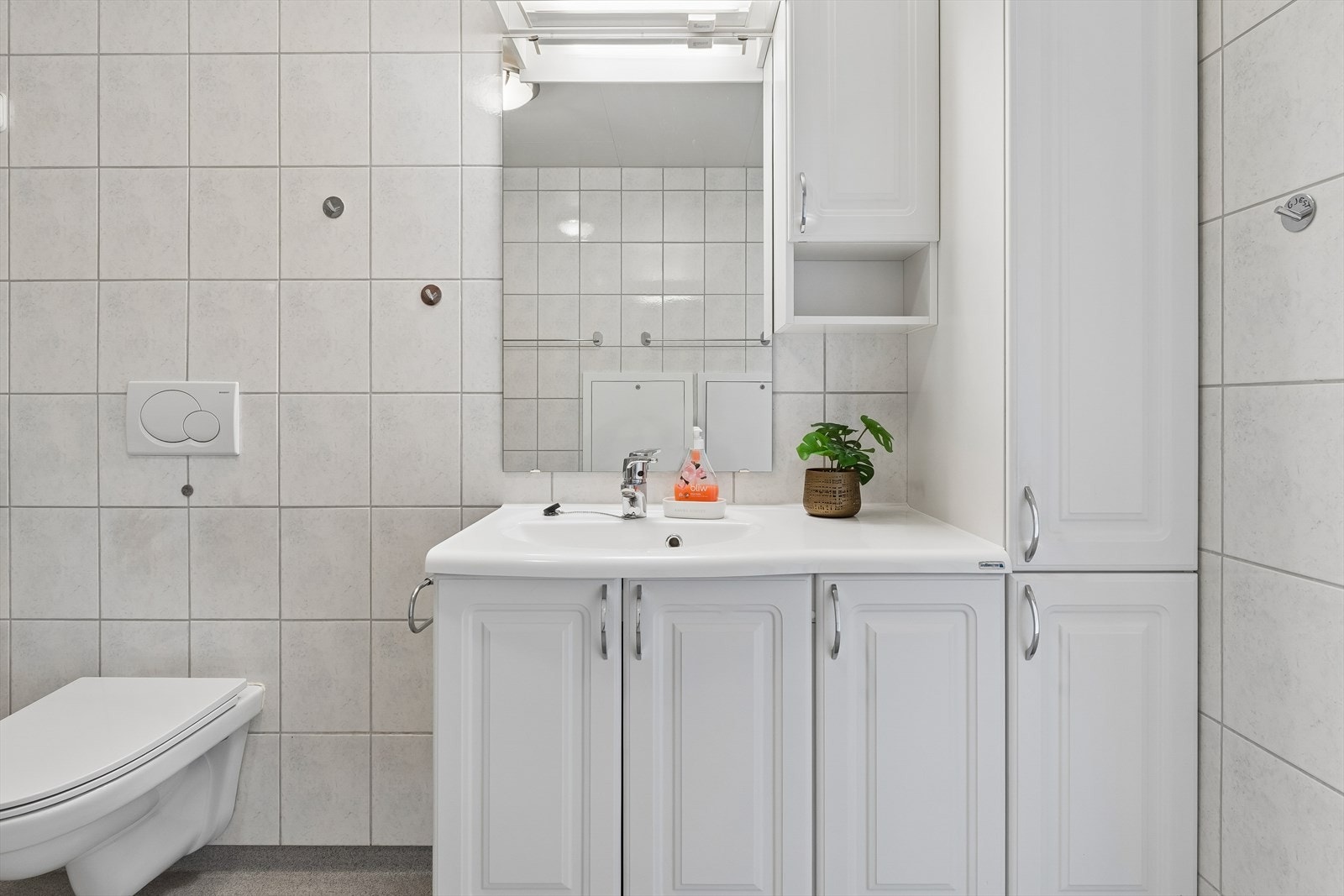 Badet har innredning med nedfelt servant, speil, overskap og høyskap som gir gode oppbevaringsmuligheter. Galleribilde