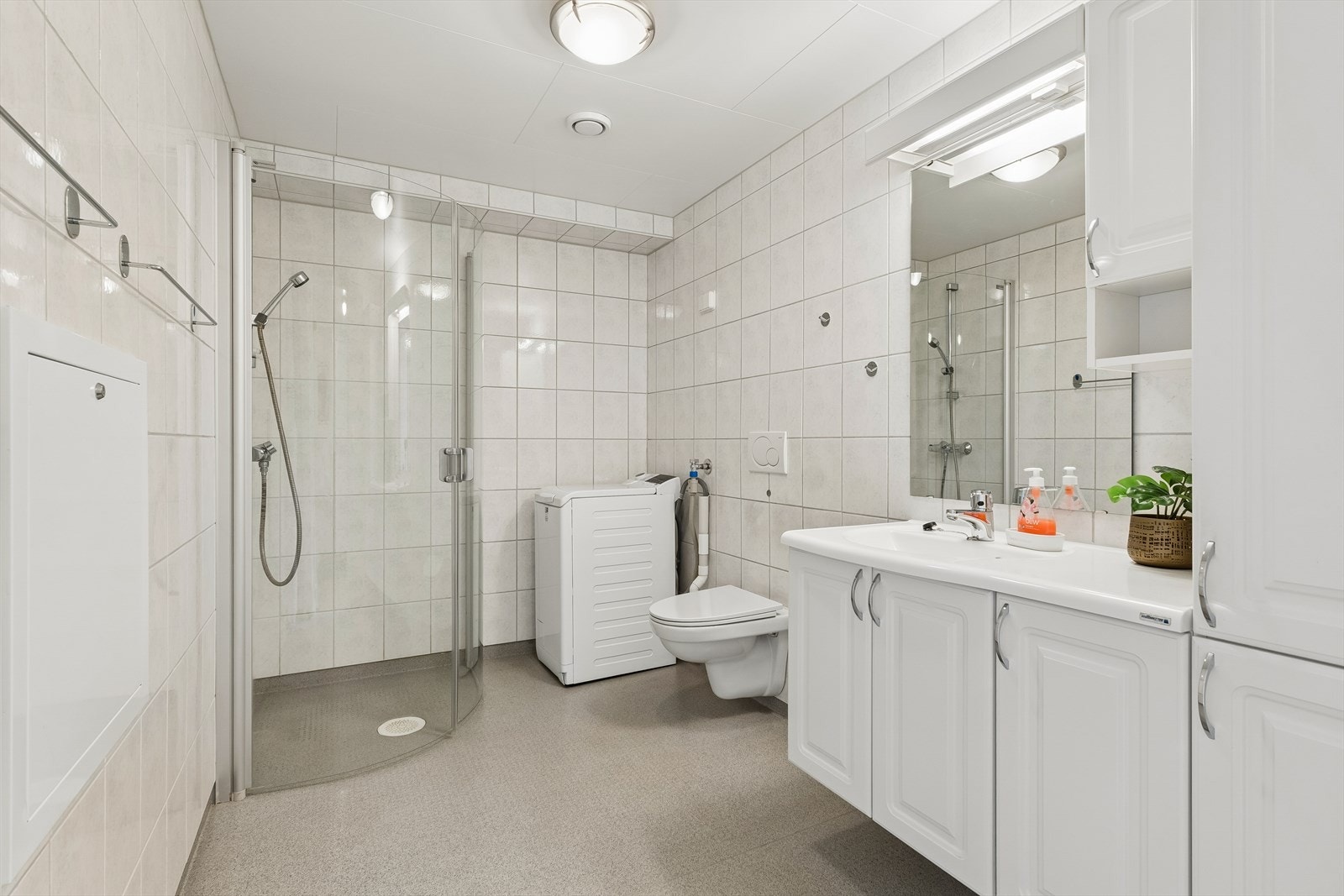 Badet har flislagte vegger, vinylbelegg på gulv med elektriske varmekabler og opplegg for vaskemaskin. Galleribilde