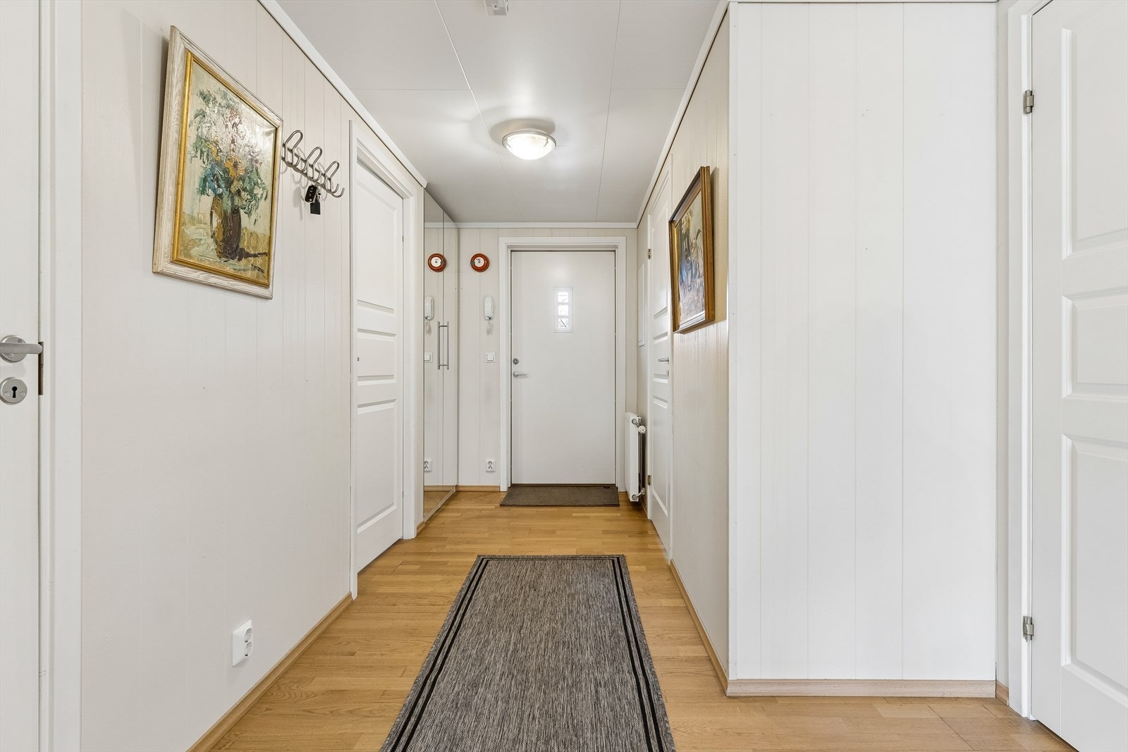 Entréen ønsker velkommen inn og har parkett på gulv, som er gjennomgående i leiligheten. Galleribilde