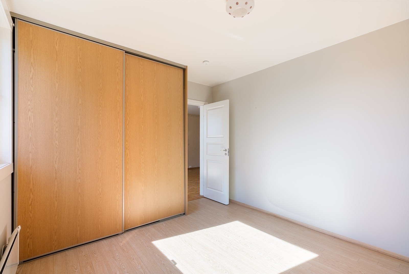 Rommet er også utstyrt med en stor skyvedørsgarderobe som gir rikelig med oppbevaringsplass. Galleribilde