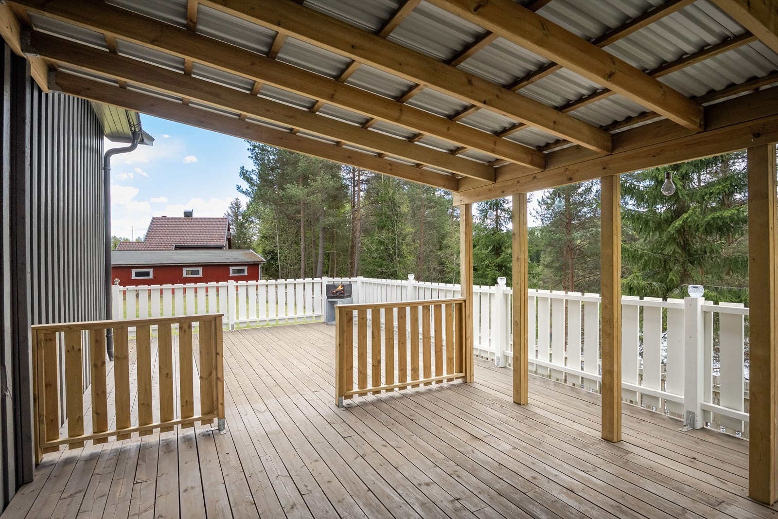 Terrassen har terrassebord på gulv, malt rekkverk og god plass til ulike soner og flere sittegrupper. Galleribilde