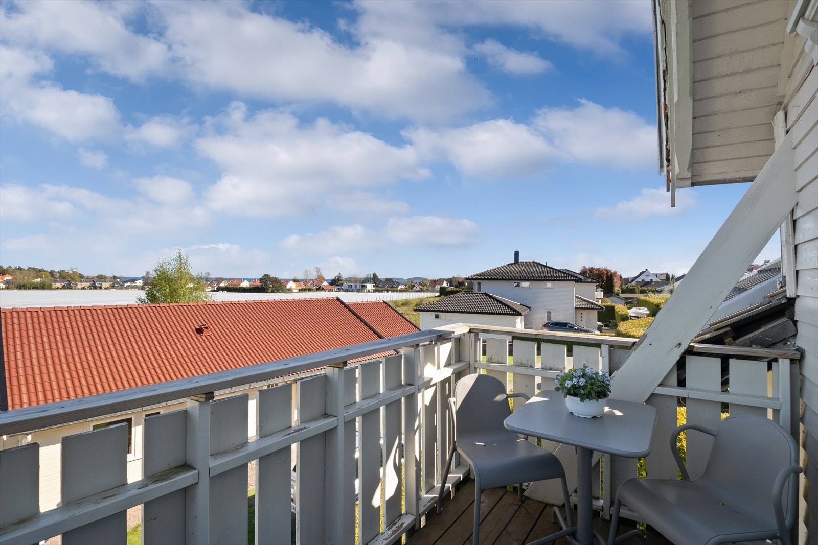 Balkongen har tredekke og rekkverk av tre, med plass til en liten sittegruppe. Galleribilde