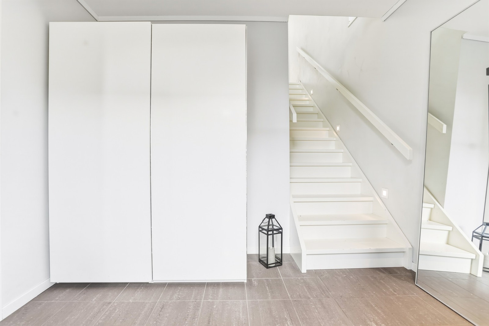 Lys og innbydende entré med flislagt gulv. Plass til oppbevaring av yttertøy og sko, blant annet i garderobe. Belyst trapp tar deg opp til boligens hoveddel Galleribilde
