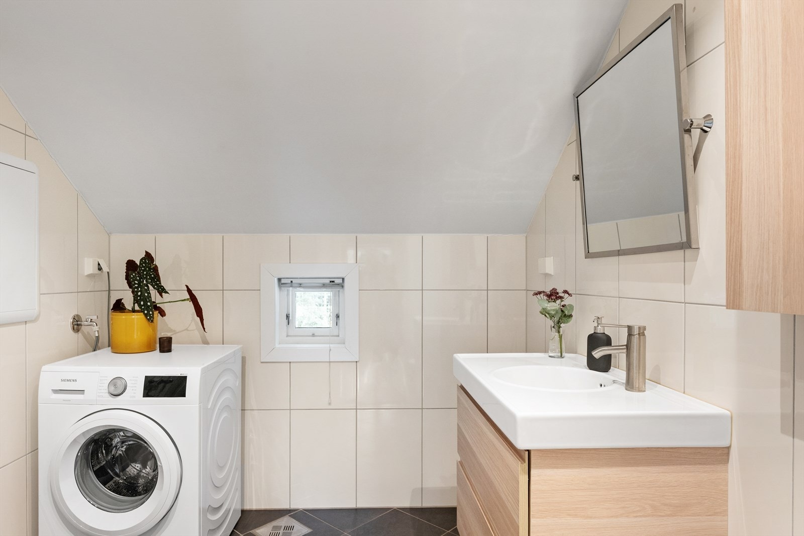 Badet er utstyrt med helstøpt servant med skuffer og har opplegg for vaskemaskin. Galleribilde