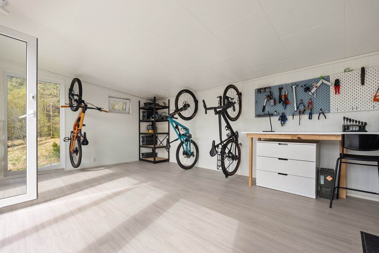Innvendig er uthuset et lyst og praktisk rom, perfekt for sykkelverksted eller hobbyaktiviteter. Galleribilde
