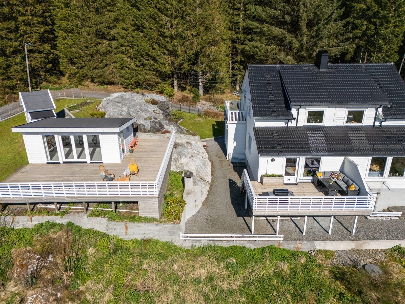 Eiendommen byr på rikelig med uteplass, med en terrasse på 21,9 m² fra stuen og en separat terrasseplatting på cirka 78 m² ved uthuset. Galleribilde