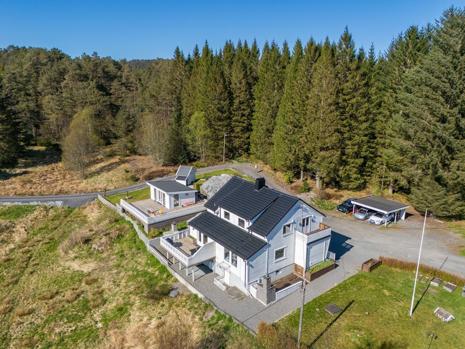 Eiendommen har en gruslagt biloppstillingsplass og carport. Galleribilde