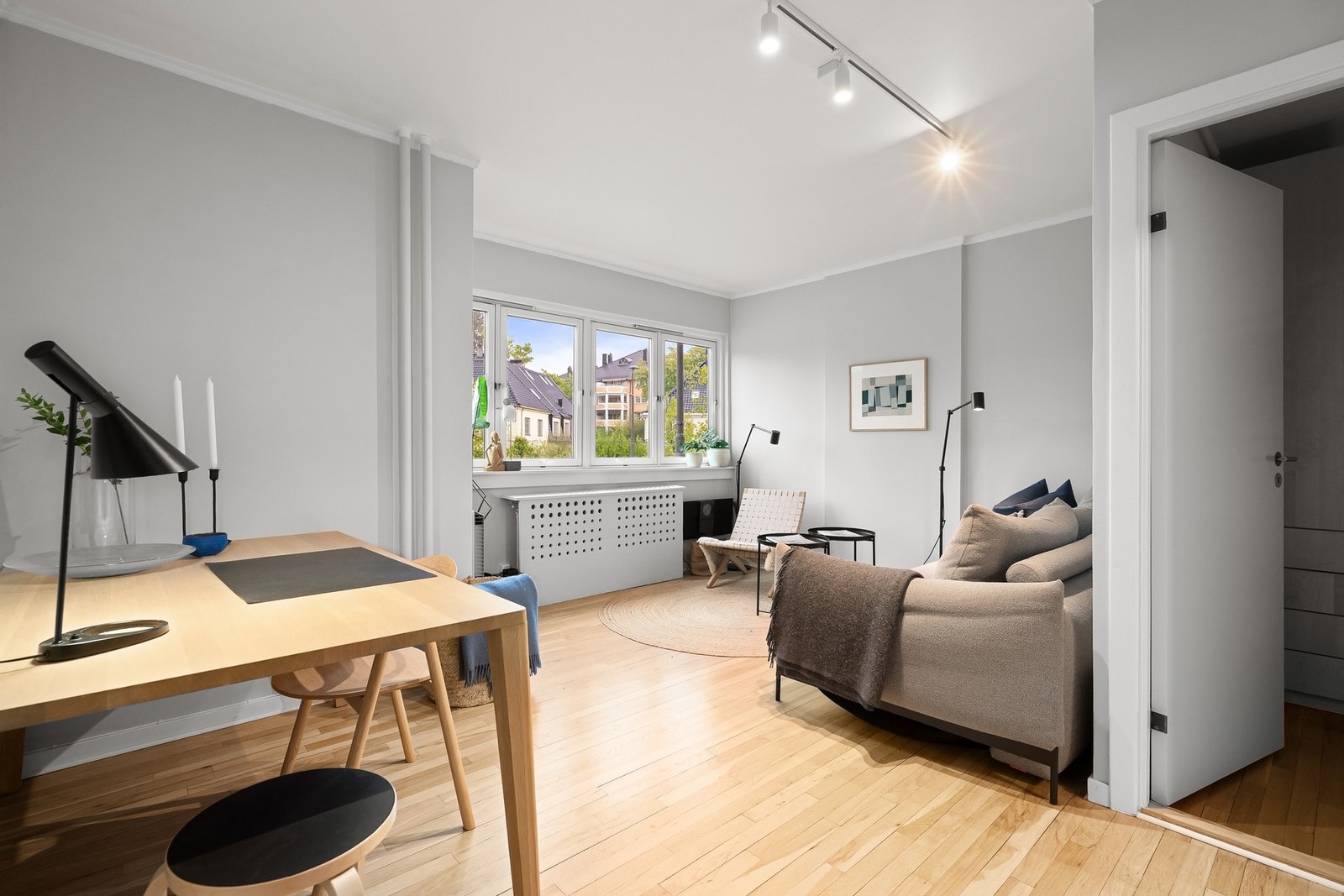 Stuen har originale eikebord, gråmalte vegger og et innebygd kott for praktisk oppbevaring. Galleribilde