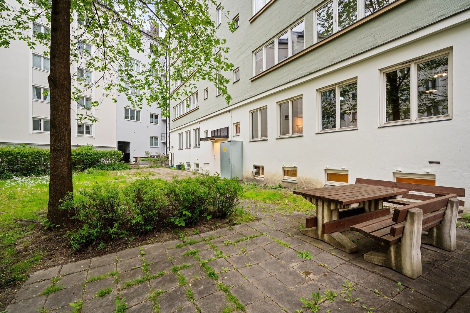 Bakgården er skjermet og opparbeidet med gressplen, beplantning og sittegrupper. Galleribilde