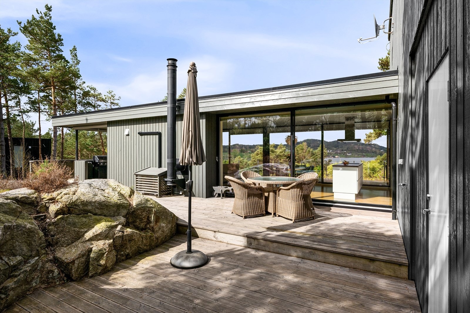 Lun og skjermet solkrok med store terrasser også på baksiden. Utsikten nyter du også herfra grunnet den smarte løsningen. Pene kontraster mellom berg og tre. Galleribilde