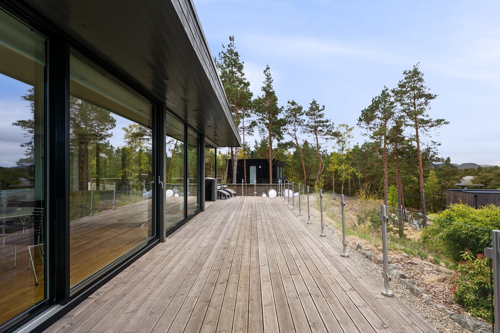 Rikelig med plass til møblering for alle anledninger. Glassrekkverk for å optimalisere utsikt og naturlig lys, samt kontakt med naturen rundt. Galleribilde