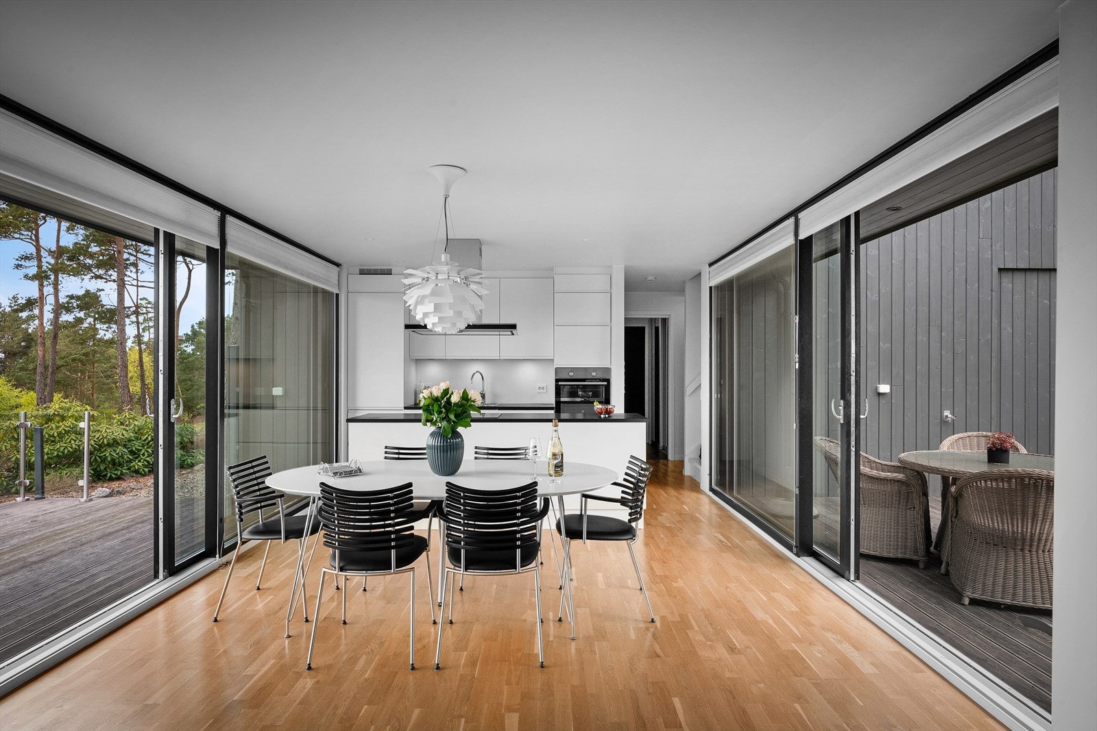Skyvedører på begge sider med terrasser for enhver anledning. Utsikten til fjorden tar du med deg også på baksiden til den lune solkroken - ettersom du har skyvedører med glass fra gulv til tak. En fantastisk løsning som kan åpnes helt opp. Galleribilde