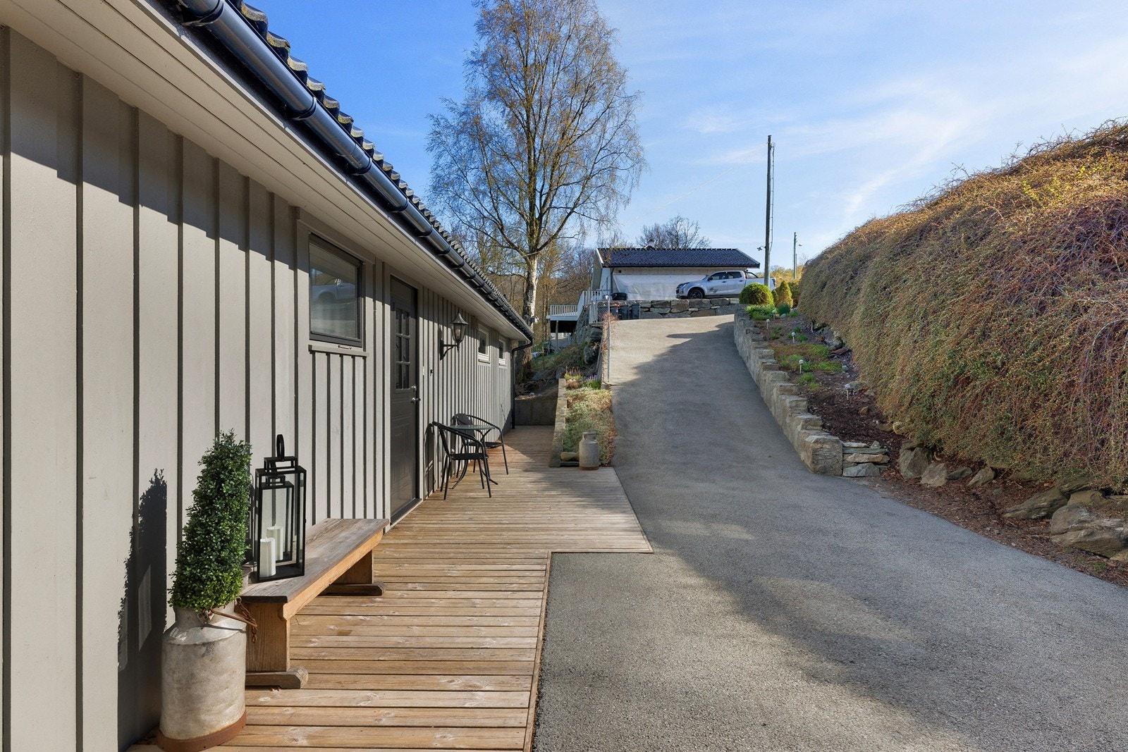 Langs innkjørselen er det pent opparbeidet med steingård og beplantning. Galleribilde