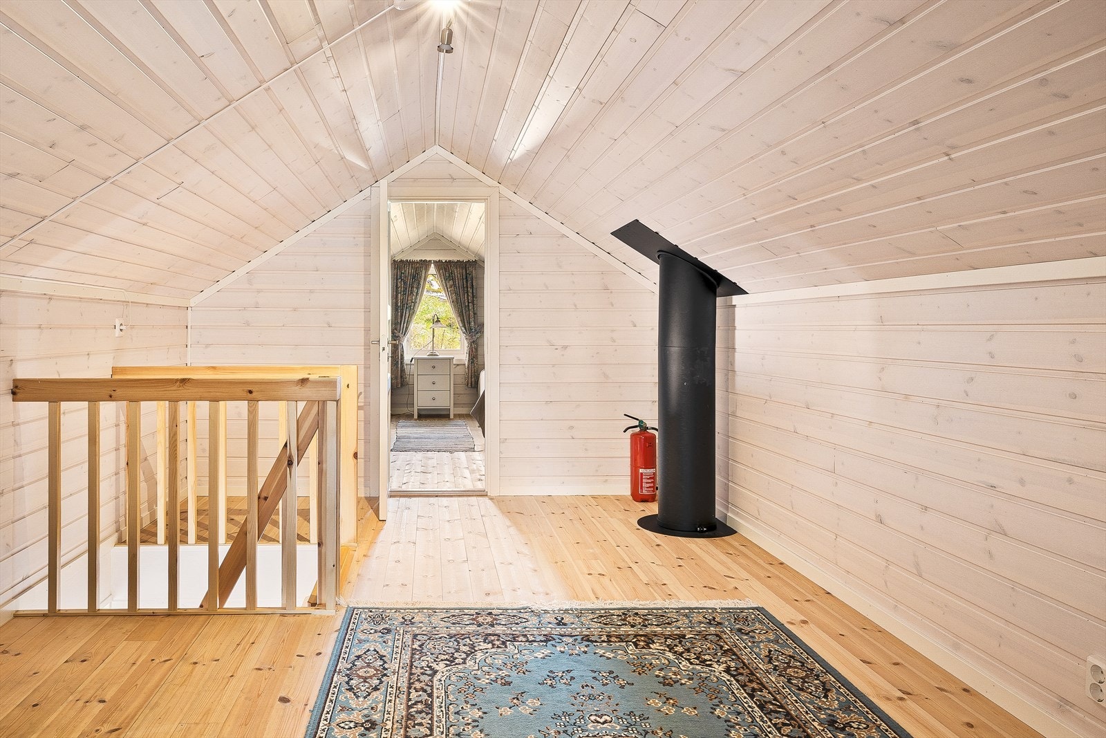 Fra entréen leder en trapp opp til loftsetasjen. Her finner man en koselig loftsstue som egner seg godt som ekstra oppholdsrom. Galleribilde