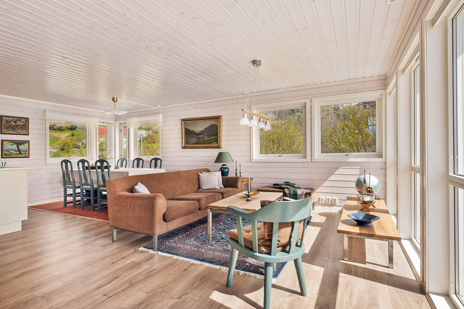 Rommet har god plass til både sofagruppe og spisebord, noe som gjør det til et naturlig samlingspunkt for hyggelige stunder med familie og venner. Galleribilde