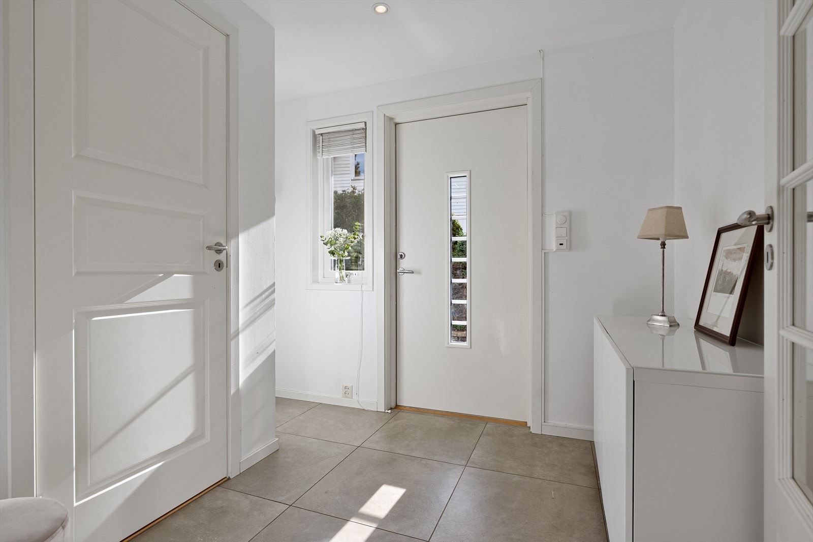 Gangen er fliser på gulvet med varmekabler og downlights i taket. Galleribilde