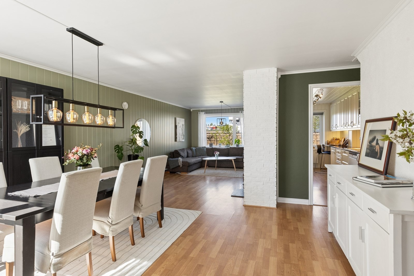 Gjennomgående laminatgulv og panelplater på veggene skaper en helhetlig stil i første etasje. Galleribilde