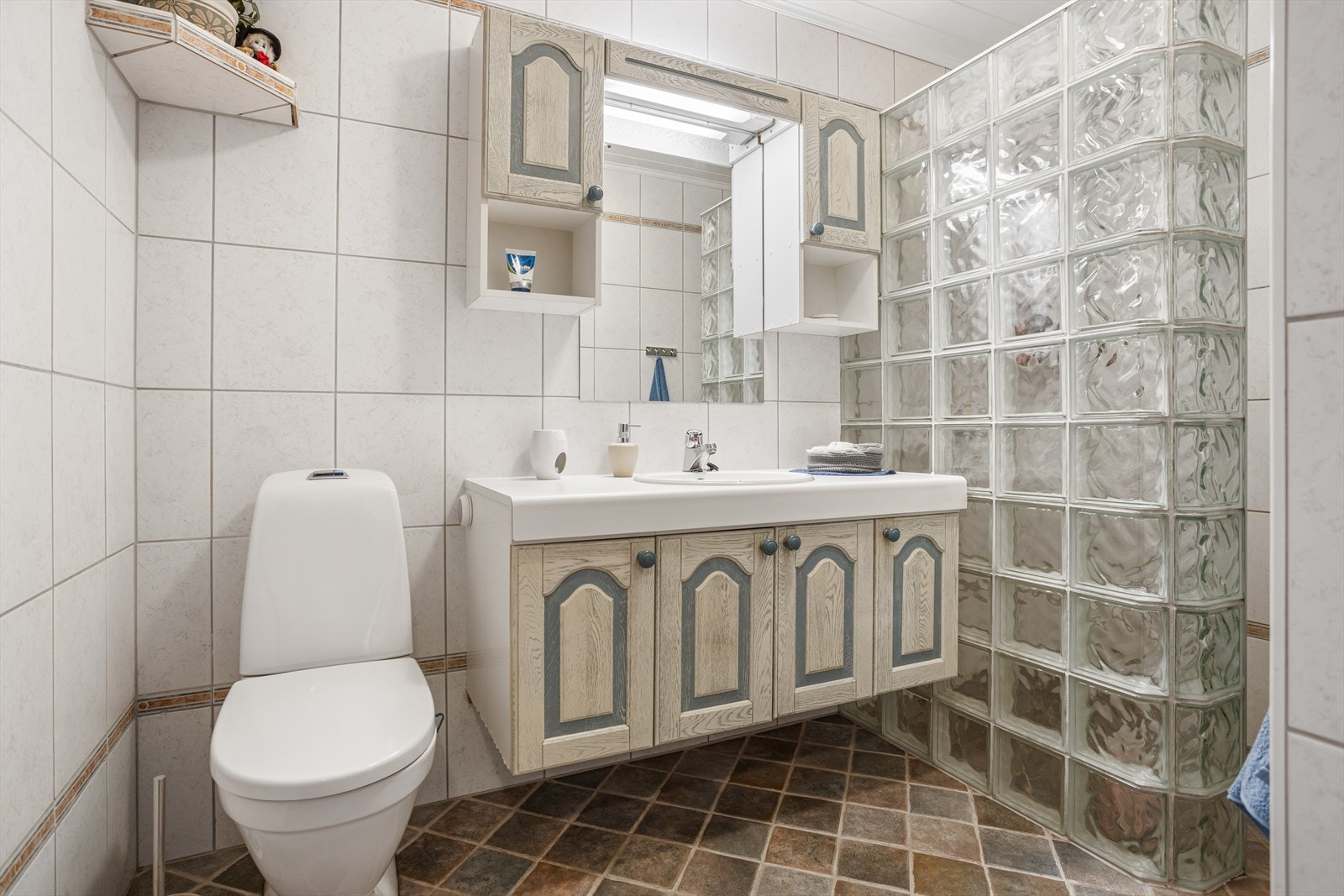 Badet i første etasje er fra 1999 og har flislagt gulv med varmekabler og en dusjnisje i glassbyggestein. Galleribilde