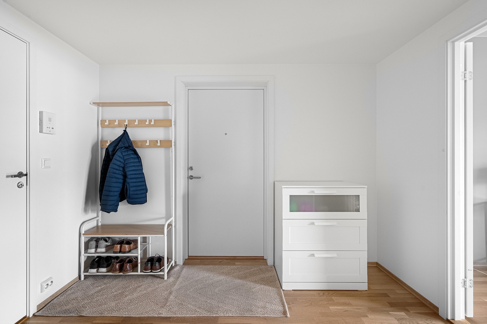 Entréen er lys og har parkett på gulvet. Galleribilde