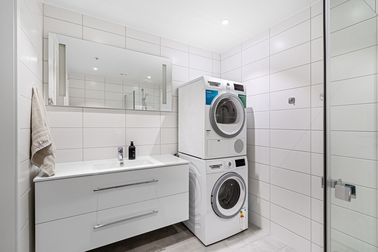Badet har flislagte gulv og vegger samt vannbåren gulvvarme. Opplegg for vaskemaskin og tørketrommel. Galleribilde