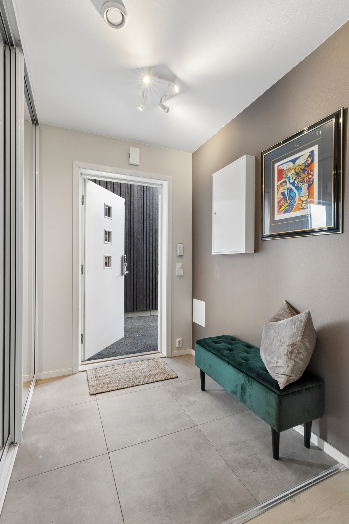 Boligen ønsker deg velkommen med en lys og romslig entré med moderne 60x60 fliser og gulvvarme. Galleribilde