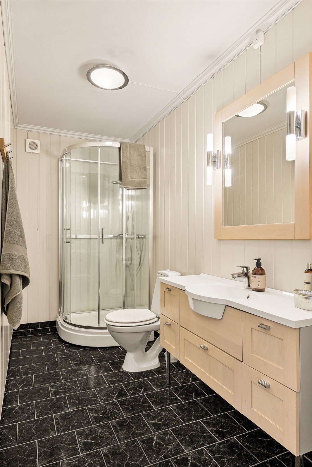 Badet er romslig og har flis på gulv og plater på vegger. Det er varmekabler i gulvet. Galleribilde