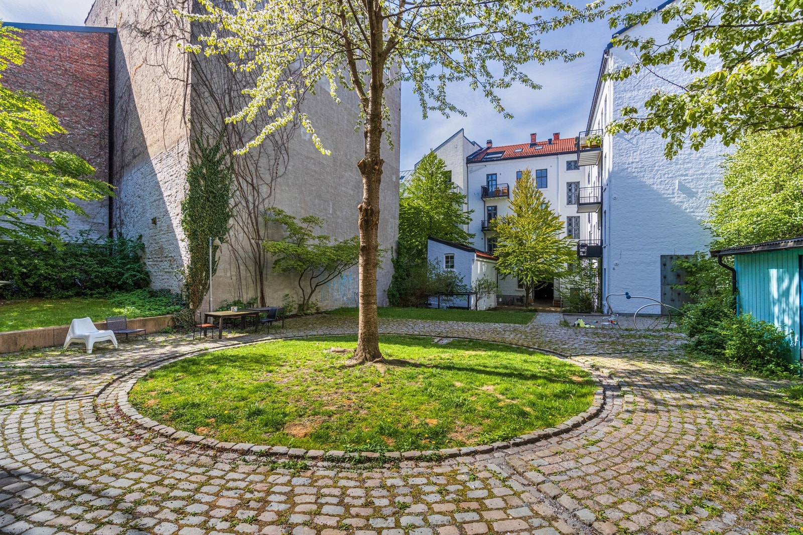 Skjermet og grønn bakgård med hyggelige oppholdssoner for sameiets beboere Galleribilde