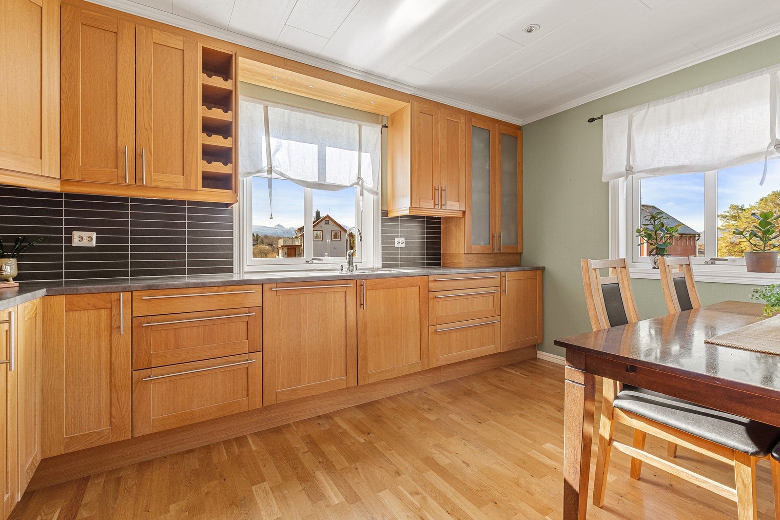 Laminat benkeplate og kitchenboard over benken gir en praktisk og vedlikeholdsvennlig arbeidsflate. Galleribilde