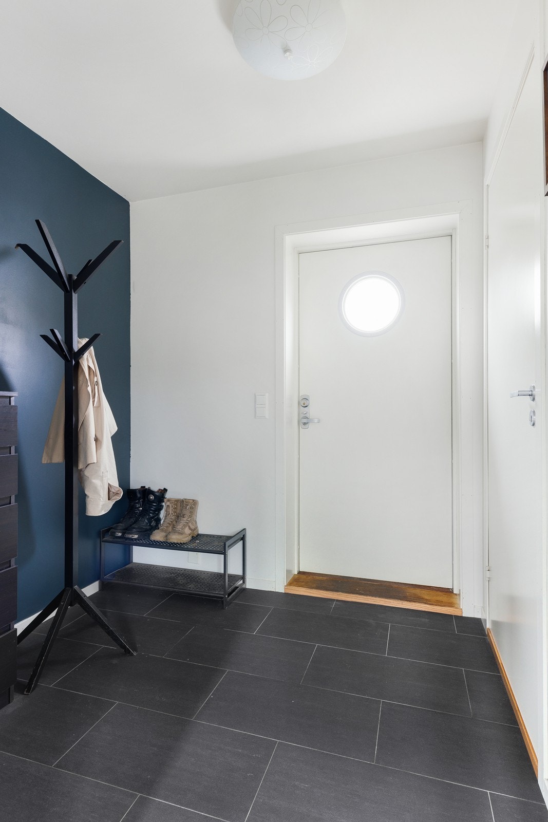 Lys entré med god plass til klær og sko. Fliser på gulv og gips på vegg. Galleribilde