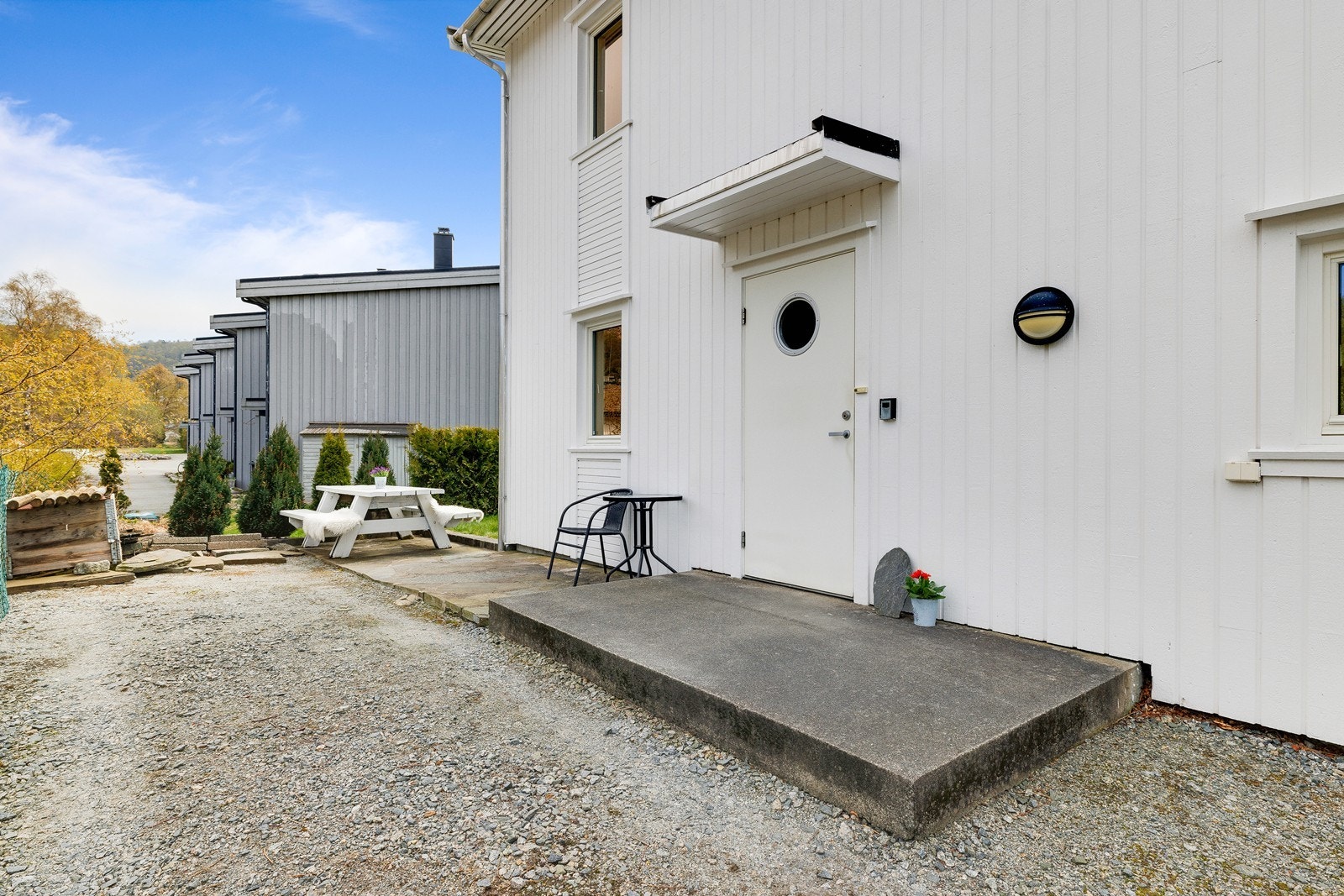 Platting i mur ved inngangspartiet - perfekt for benk, blomster eller morgenkaffe. God plass til parkering i eget gårdsrom og carport. Galleribilde