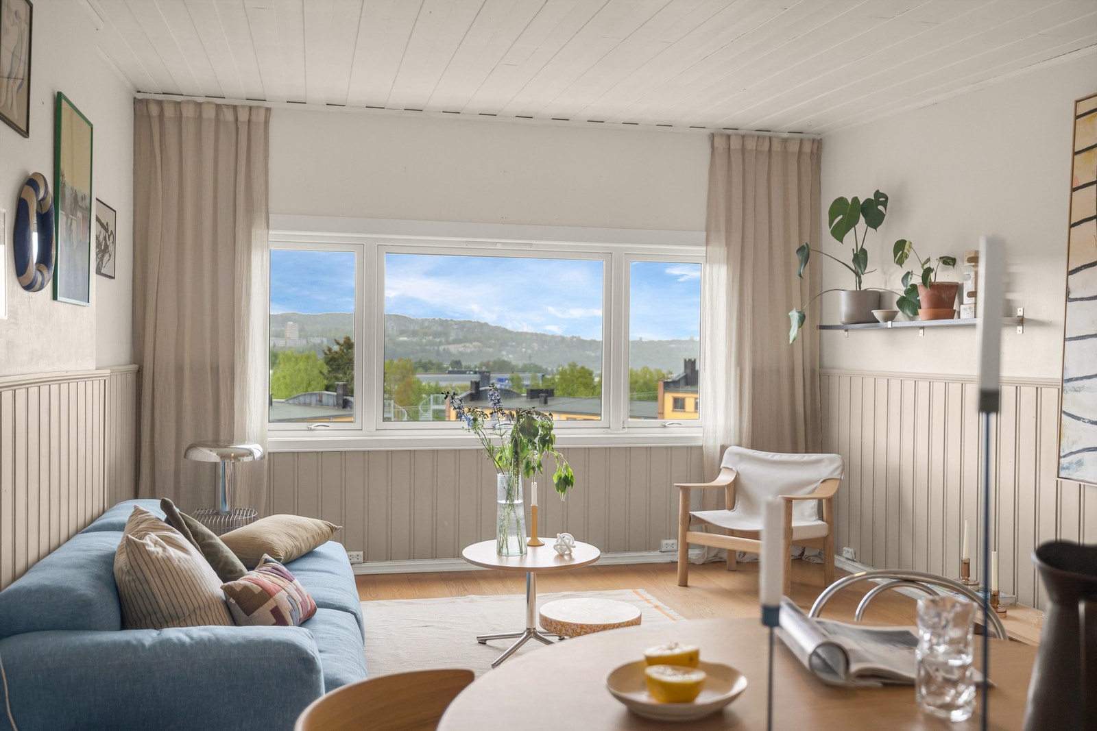 Stuen oppleves som lys og romslig med store vindusflater som slipper inn godt med naturlig lys og gir fin utsikt mot grønne omgivelser. Galleribilde