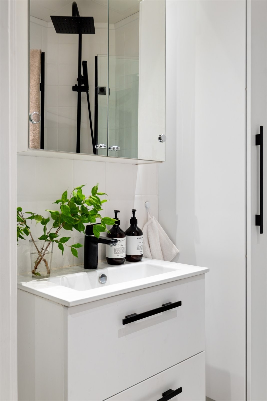 I dag fremstår badet som innbydende med lyse fliser og mørke detaljer på innredningen. Galleribilde