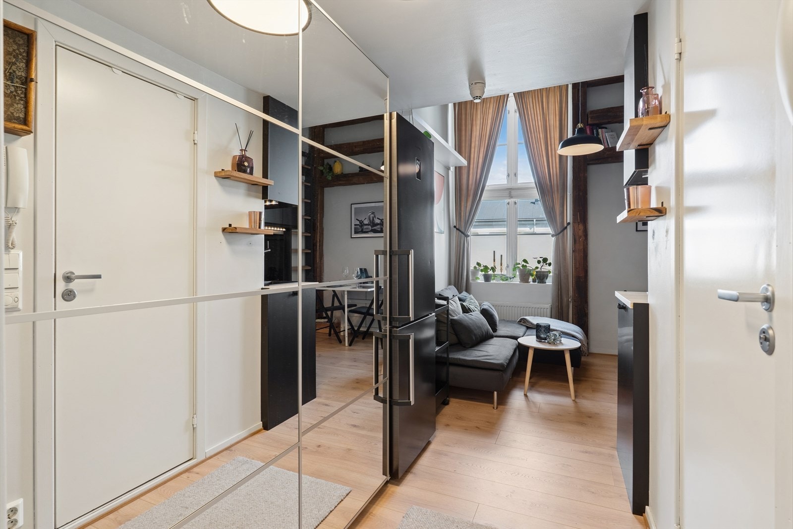 Velkommen inn i en lys og innbydende entré med praktisk oppbevaring og direkte adkomst til det åpne oppholdsrommet Galleribilde