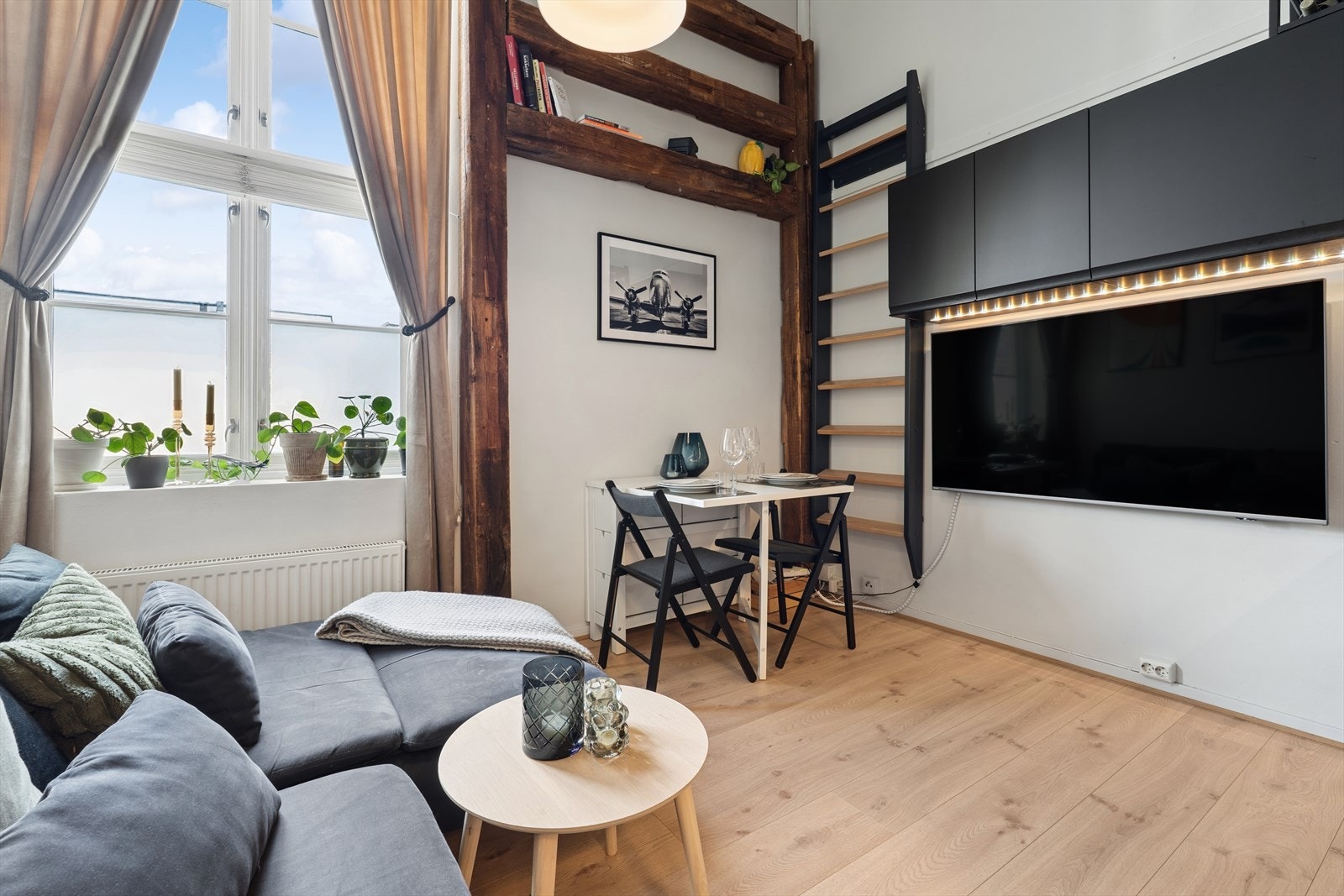 Stuen fremstår lys, luftig og svært innbydende, takket være store vindusflater som slipper inn rikelig med naturlig lys og den høye takhøyden som gir atmosfære Galleribilde