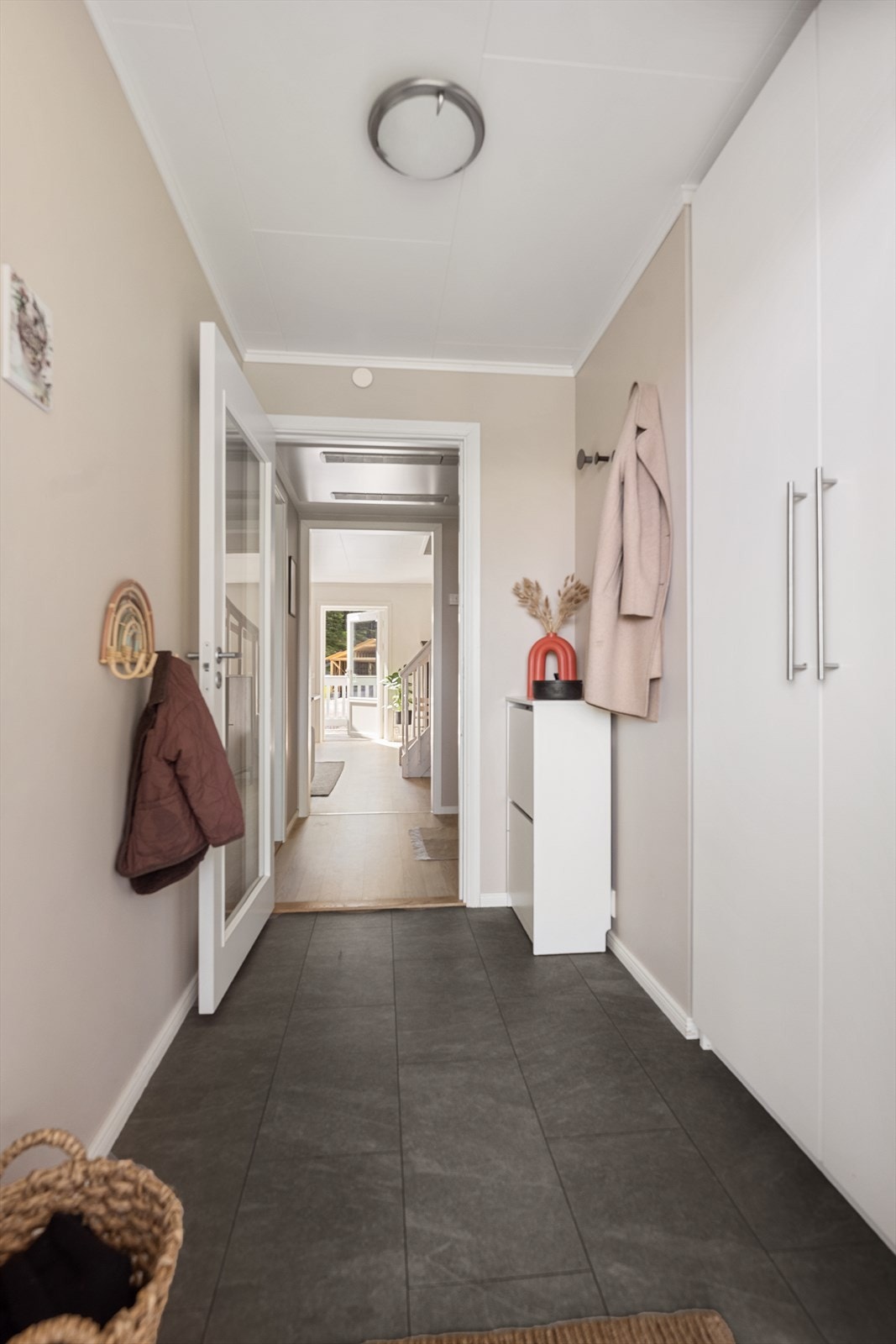 En dør med glassfelt mellom entré og gang slipper lyset videre inn i etasjen. Galleribilde