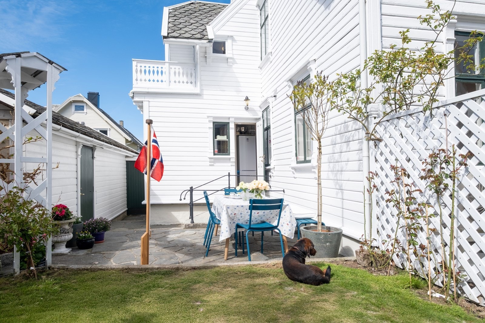 Solrik og innbydende uteplass med steinlagt tun, grøntarealer og flere hyggelige oppholdssoner. Galleribilde