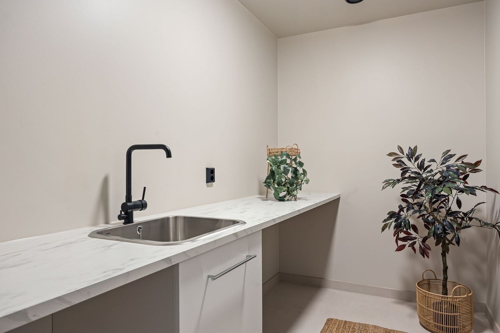 Praktisk vaskerom med opplegg for vaskemaskin, tørketrommel og oppbevaring. Videre adkomst til teknisk rom. Galleribilde