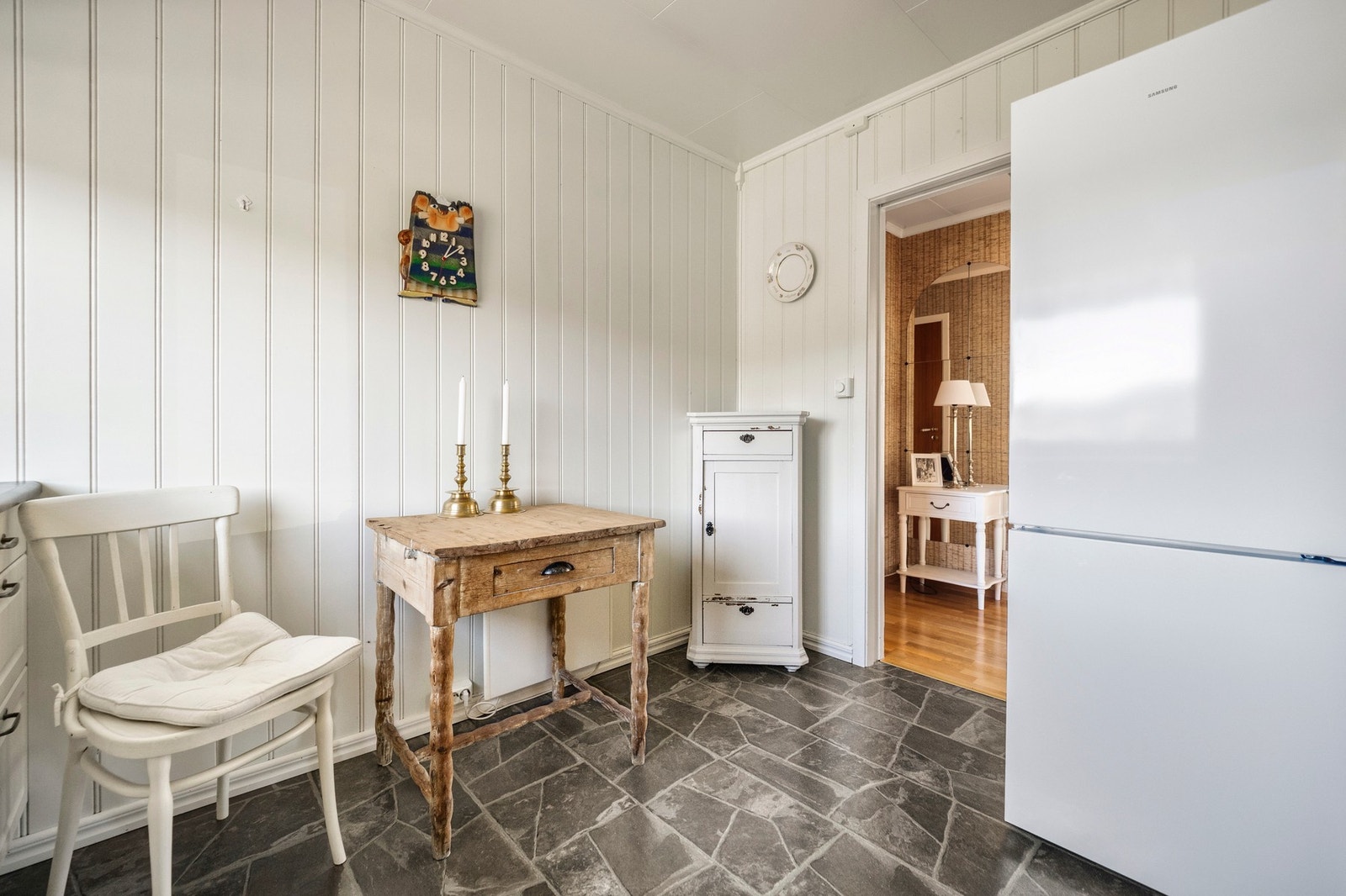 Det er komfyr og oppvaskmaskin i benk, og plass til frittstående kjøleskap samt et lite kjøkkenbord Galleribilde