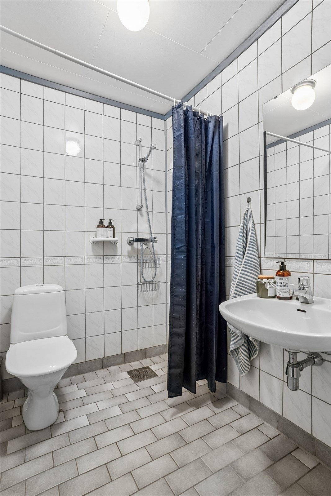 Bad i underetasjen med flislagt golv med varmekablar, dusj og golvmontert klosett. Galleribilde
