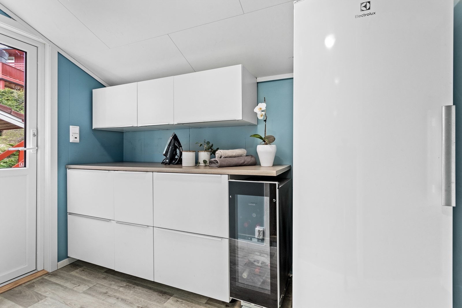 Ved sida av vaskerommet er det eigen inngang frå hagen. Her er det også godt med oppbevaring og moglegheit for ekstra kjøleskåp og frysarplass. Vinskåpet følgjer med i handelen. Galleribilde