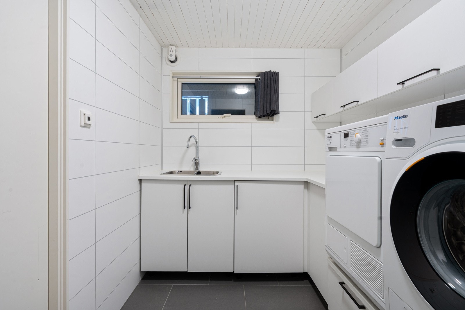 Separat vaskerom med plass til både vaskemaskin og tørketrommel. God skap- og benkeplass gir praktiske arbeidsforhold.