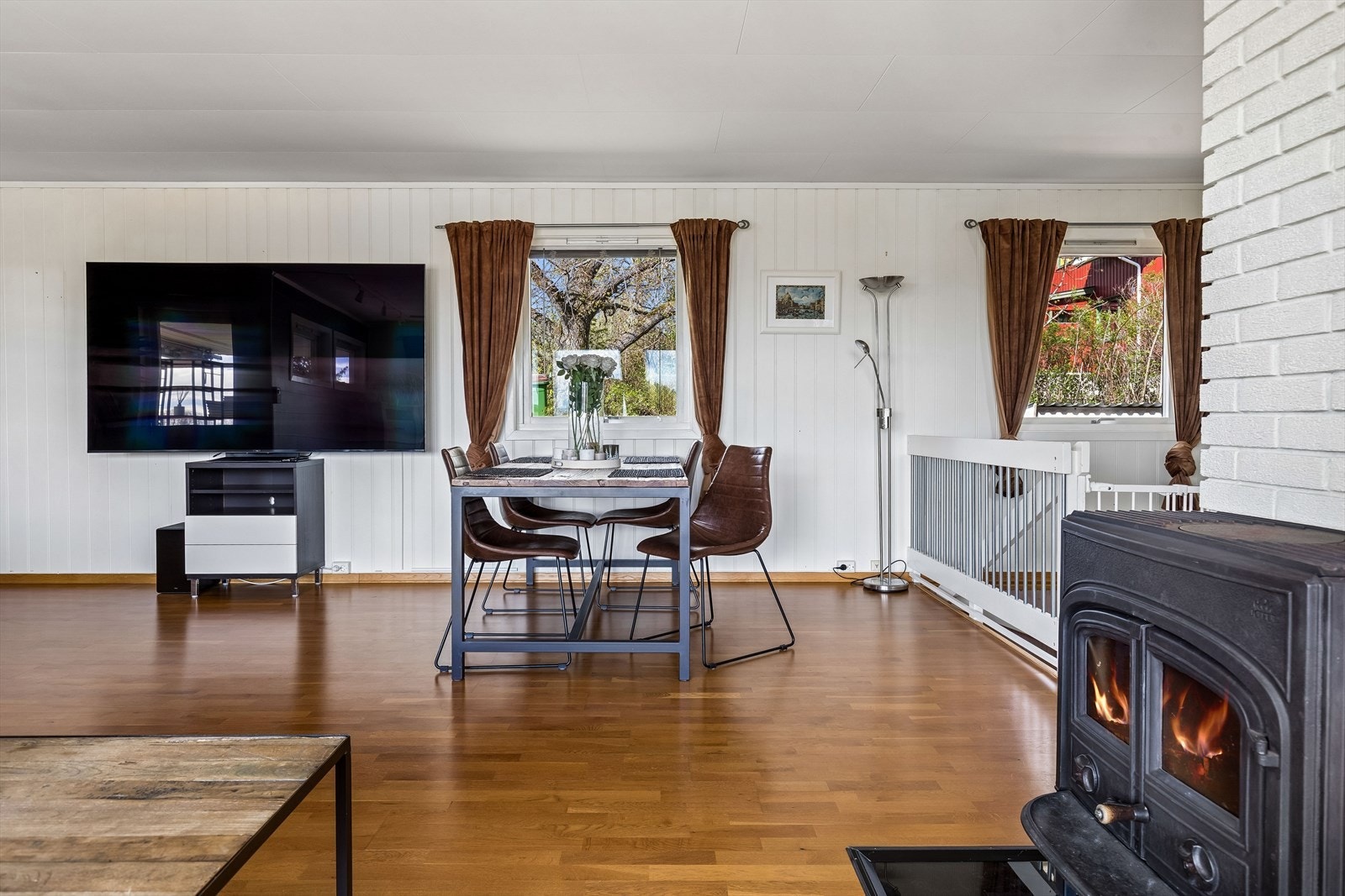 Veggflatene i stuen er en kombinasjon av malte panelplater og slette flater. Galleribilde