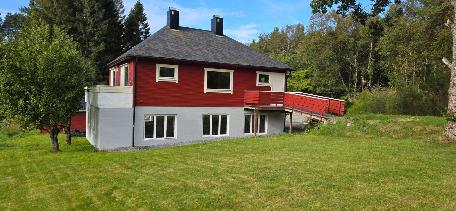 Pent uteområde bestående av plen, beplantning og ulike busker og trær. Foto: selger. Galleribilde