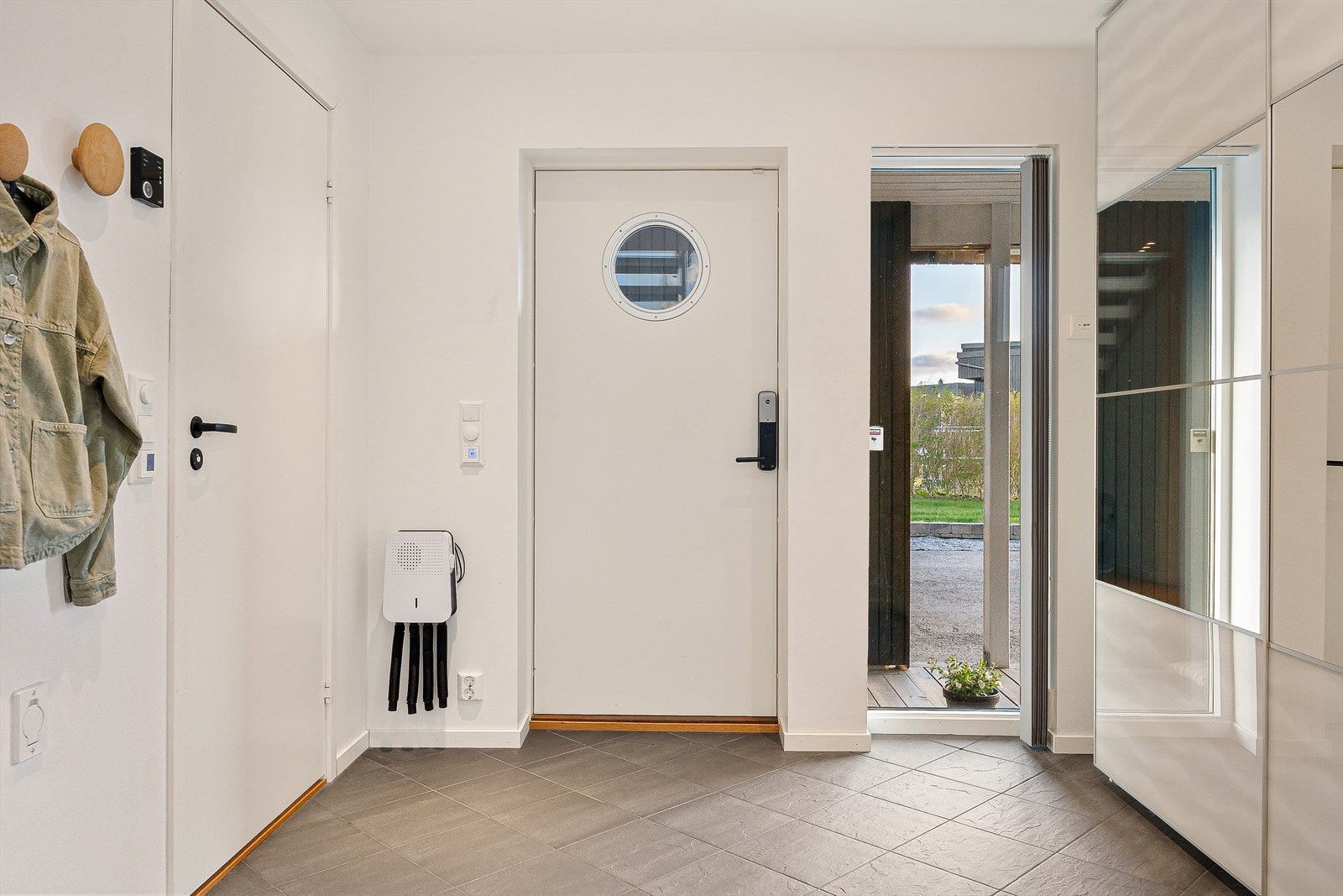 Entréen har fliser i gulv samt varmekabler. Her er det også store skyvedørsgarderober - perfekt for oppbevaring av all yttertøy. Galleribilde