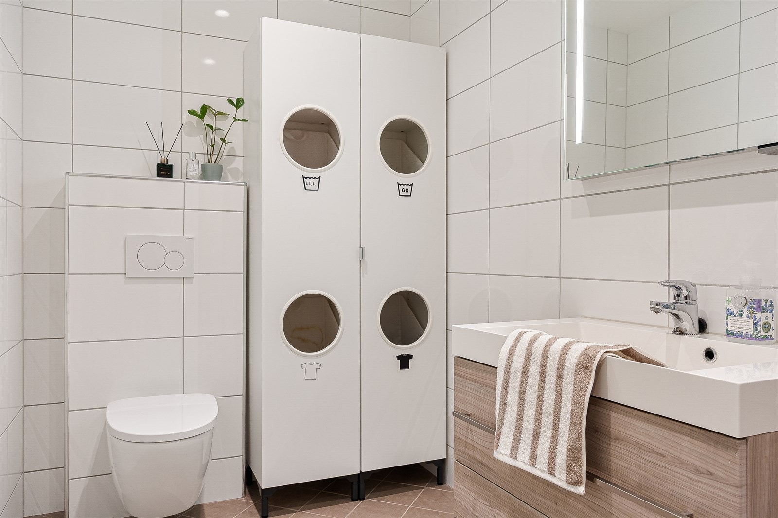 Badet er lekkert innredet med innfeltbare dusjvegger, baderomsmøblement og speil samt vegghengt toalett. Galleribilde