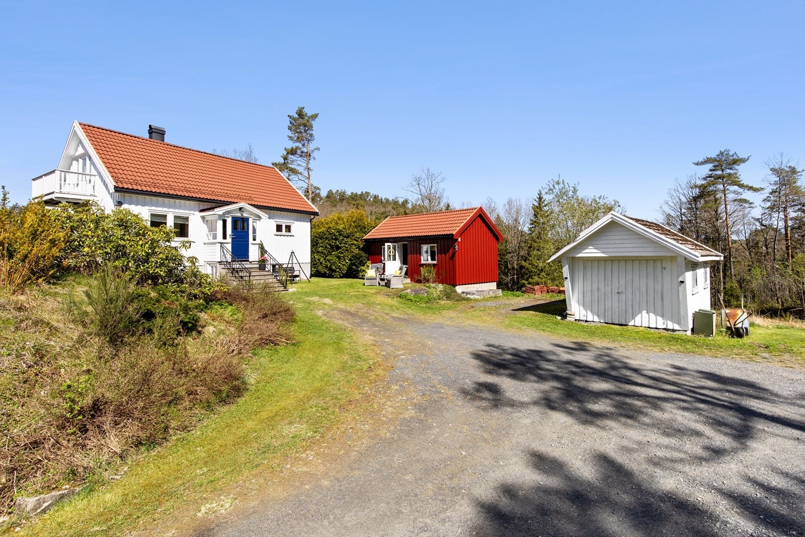 Åpent tun med naturlig tilknytning mellom bolig, anneks og en garasje av enkel standard Galleribilde