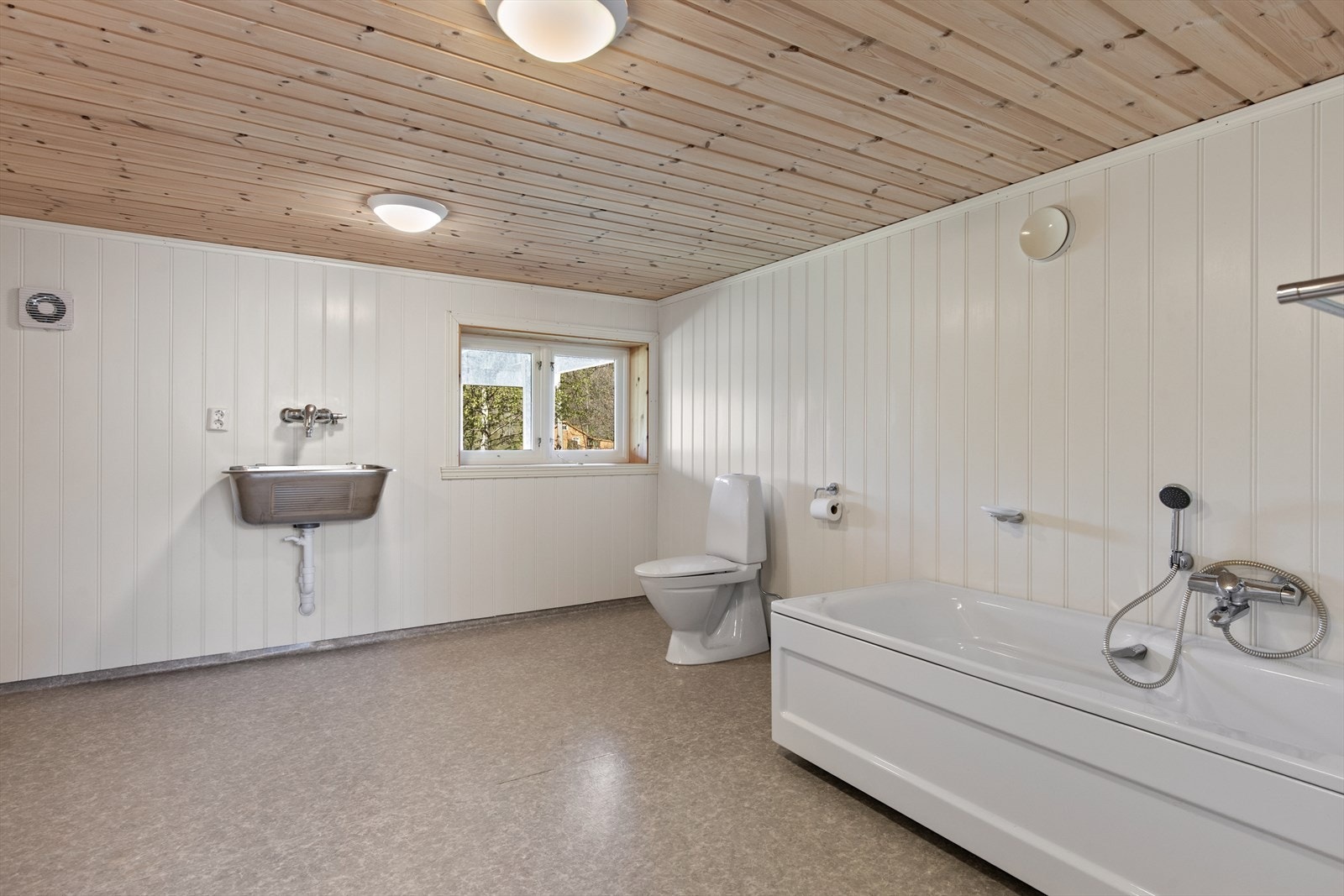 Badet har en enkel og funksjonell utforming med badekar og plass til vaskesone. Galleribilde