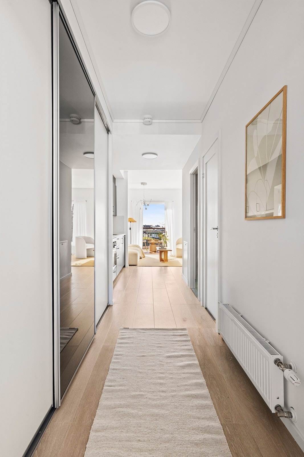 Leiligheten har en innbydende entré som ønsker deg velkommen. Her finner du en praktisk, innebygd skyvedørsgarderobe som gir god orden i hverdagen Galleribilde