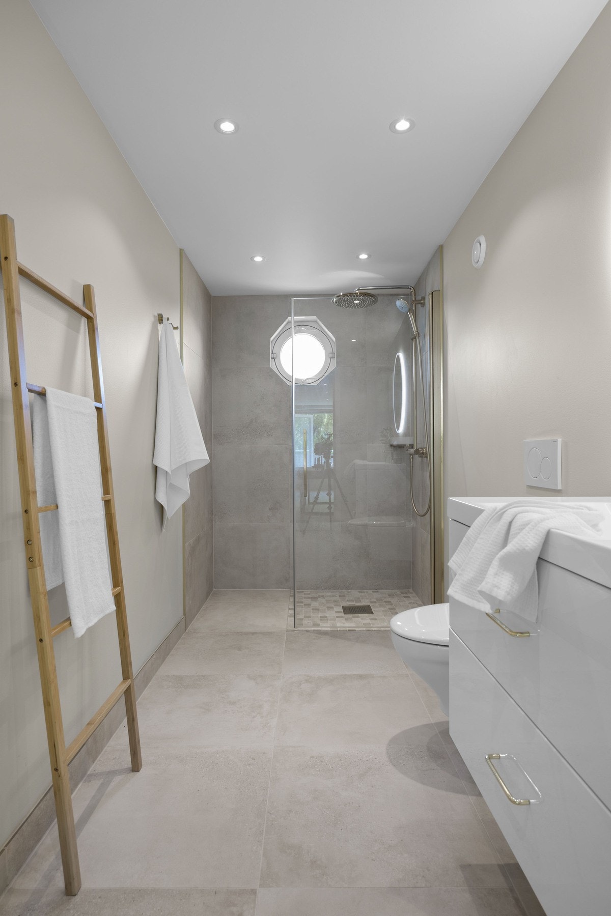 Badet er innredet med vegghengt toalett, servantseksjon med gode oppbevaringsmuligheter og speil med integrert belysning. Galleribilde